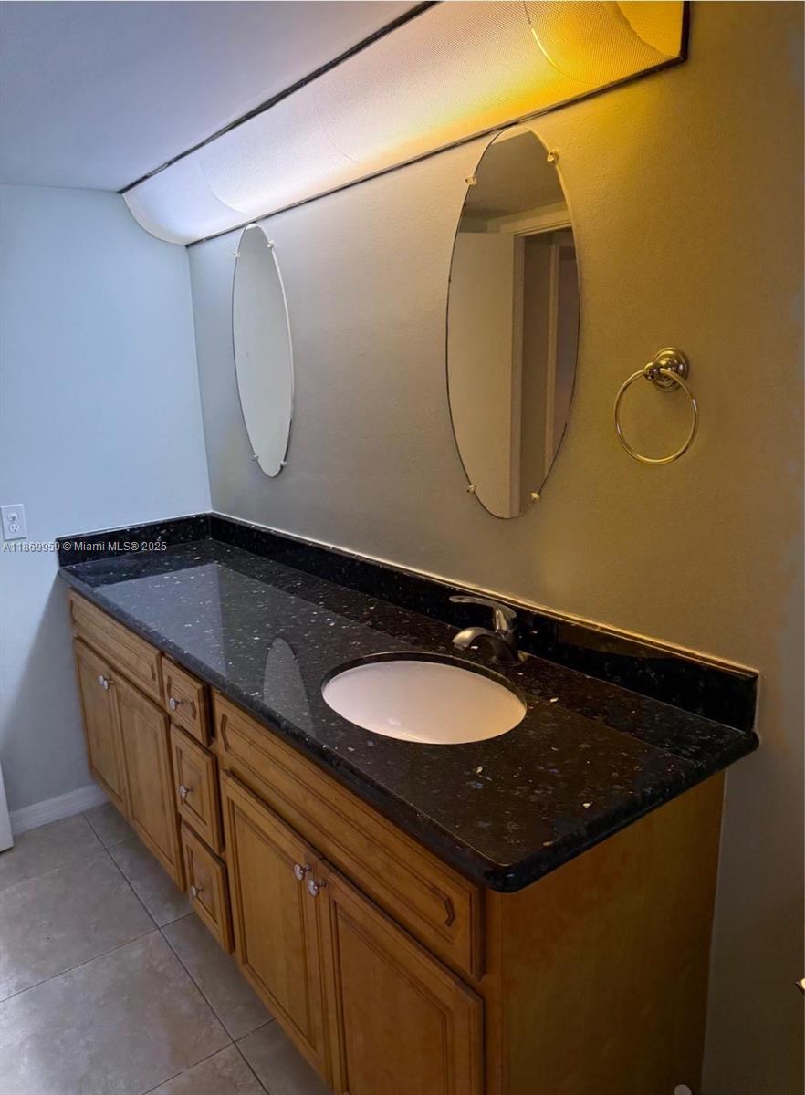 1710 Northeast 191st Street, Unit 2083 Miami, FL 33179 - Photo 31 of 36 a bathroom with a sink and a mirror