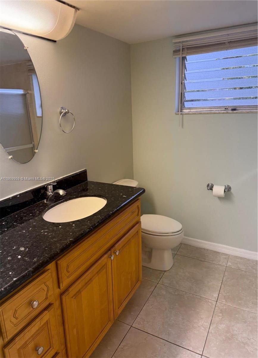 1710 Northeast 191st Street, Unit 2083 Miami, FL 33179 - Photo 33 of 36 a bathroom with a granite countertop sink and a mirror