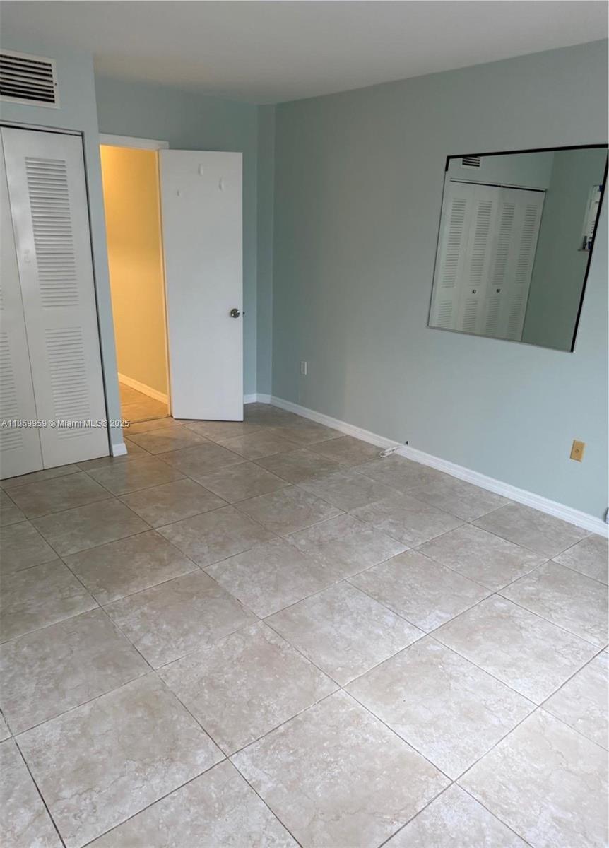 1710 Northeast 191st Street, Unit 2083 Miami, FL 33179 - Photo 6 of 36 an empty room with windows and closet