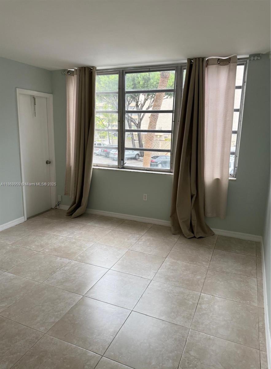 1710 Northeast 191st Street, Unit 2083 Miami, FL 33179 - Photo 7 of 36 a room with a large window and a bathroom