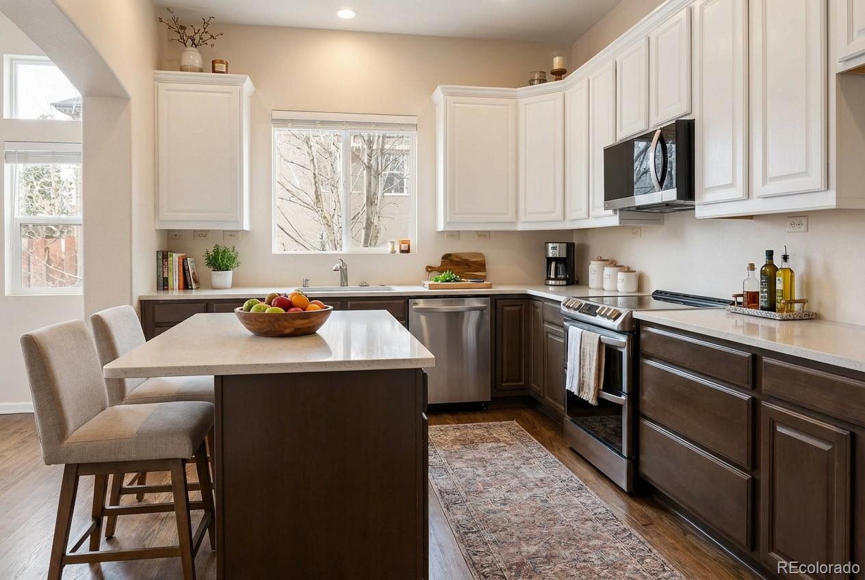 10744 Rhinestone Drive Colorado Springs, CO 80908 - Photo 4 of 24 a kitchen with stainless steel appliances a sink a stove a refrigerator cabinets and a window