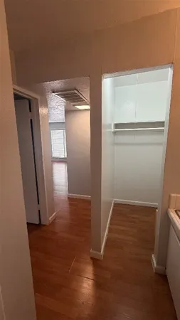 a view of empty room with wooden floor