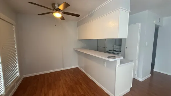 a kitchen with a refrigerator and a ceiling fan
