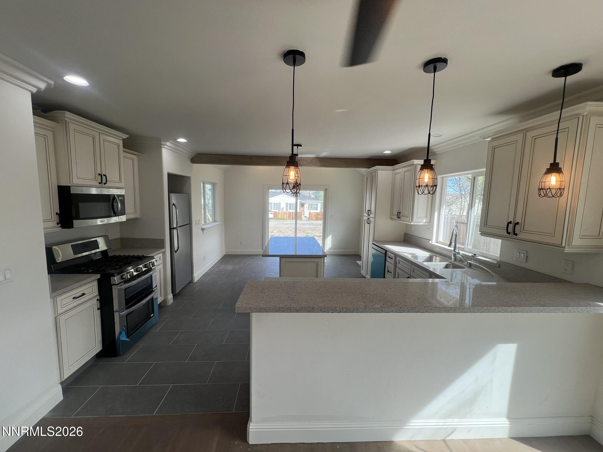 1832 H Street Sparks, NV 89431 - Photo 5 of 15 a kitchen with kitchen island granite countertop a sink a counter top space appliances and cabinets