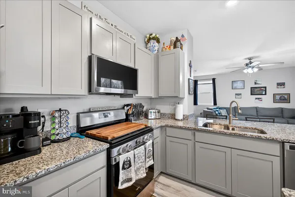 a kitchen with stainless steel appliances granite countertop a sink stove and cabinets