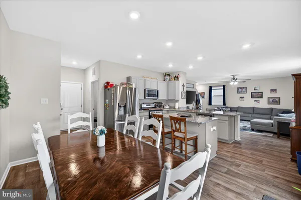 a view of a dining room and livingroom with furniture wooden floor a chandelier
