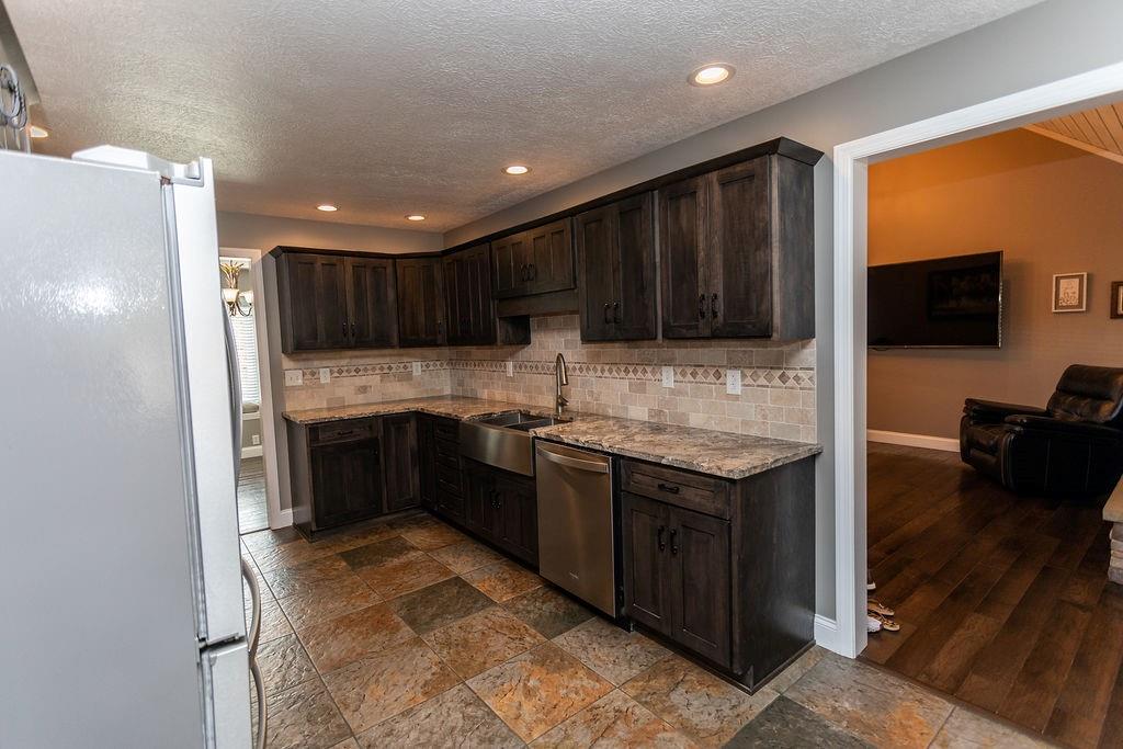 159 Reservoir Hill Road Uniontown, PA 15401 - Photo 16 of 50 a kitchen with granite countertop stainless steel appliances and wooden cabinets
