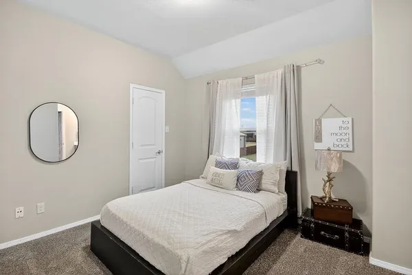 a bedroom with a bed and a window