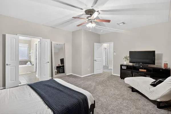 a bedroom with bed and a flat screen tv