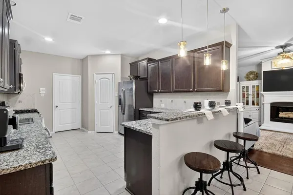 a kitchen with kitchen island granite countertop a sink counter top space appliances and cabinets