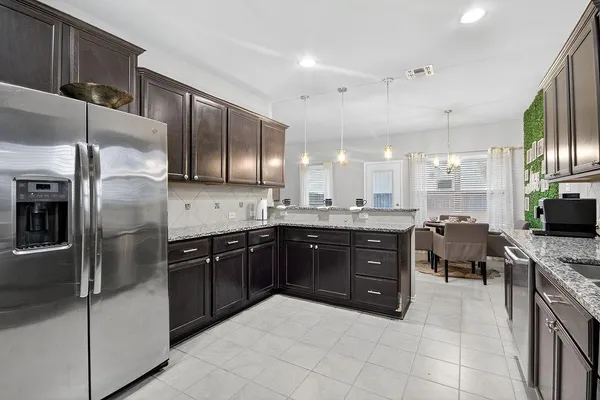 a large kitchen with stainless steel appliances lots of counter space and breakfast area