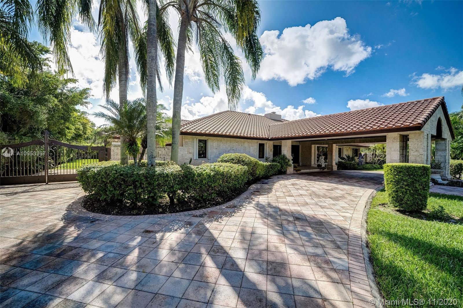 9100 Southwest 103rd Street Miami, FL 33176 - Photo 2 of 47 a view of a white house with a yard and potted plants