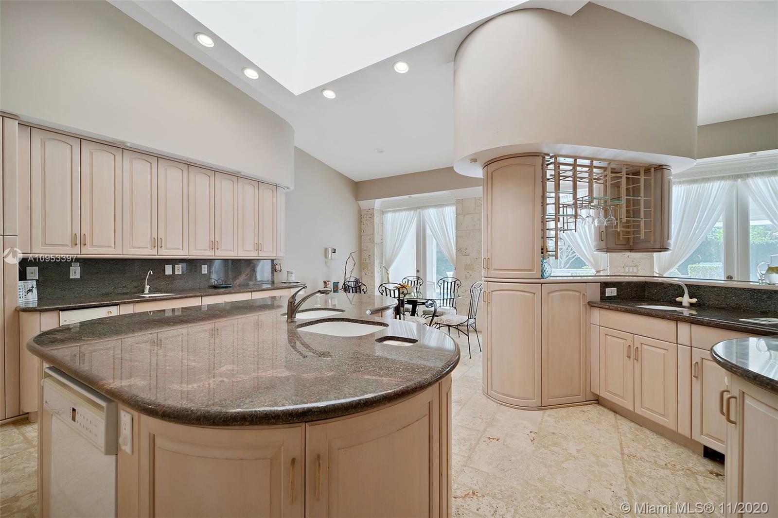 9100 Southwest 103rd Street Miami, FL 33176 - Photo 21 of 47 a kitchen with kitchen island granite countertop a sink a center island and cabinets