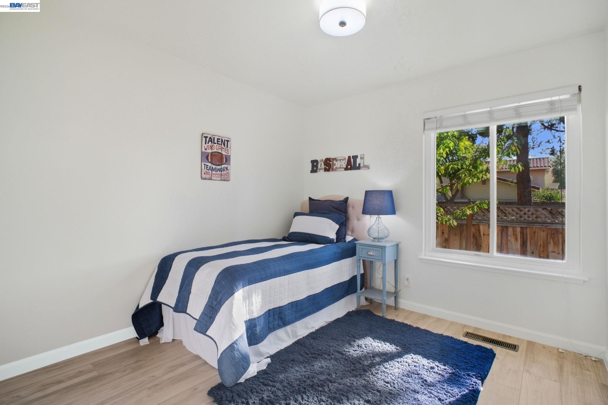 4987 Winchester Place Newark, CA 94560 - Photo 15 of 25 a bedroom with a bed and wooden floor