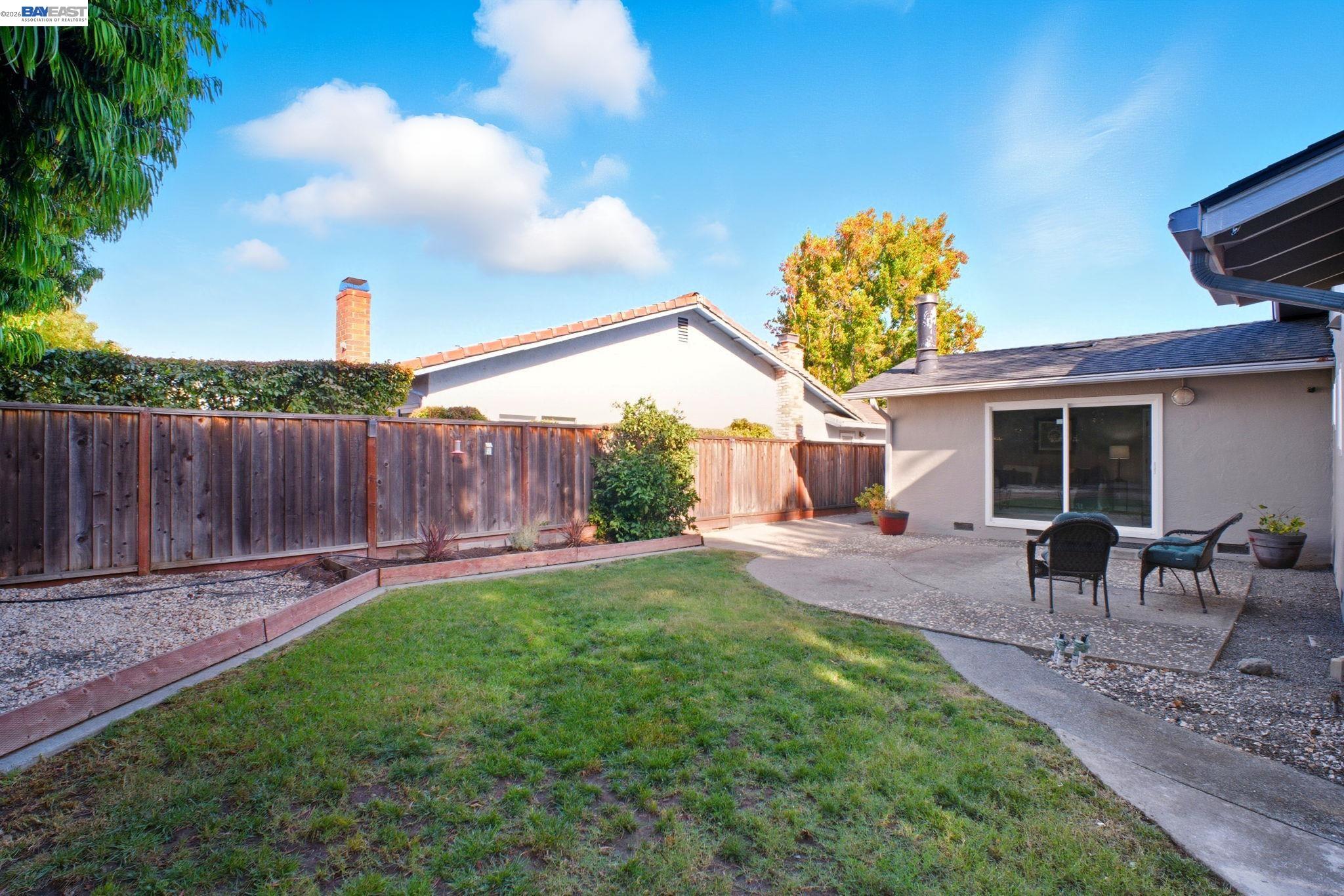 4987 Winchester Place Newark, CA 94560 - Photo 21 of 25 a view of a backyard with table and chairs potted plants and wooden fence