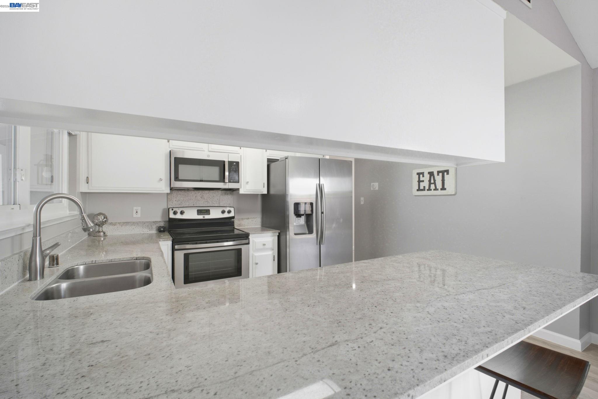 4987 Winchester Place Newark, CA 94560 - Photo 5 of 25 a large kitchen with cabinets and stainless steel appliances