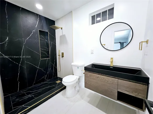 a bathroom with a sink toilet and a mirror