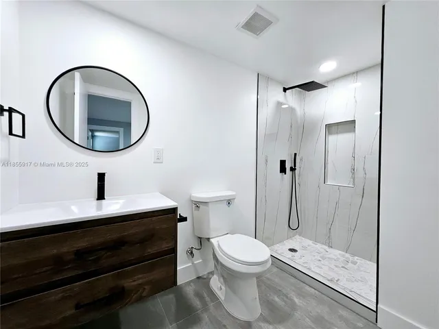 a bathroom with a toilet a sink and a mirror