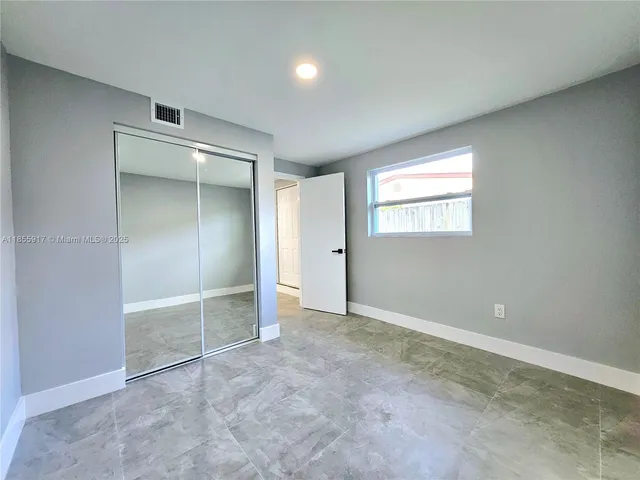 an empty room with windows and closet