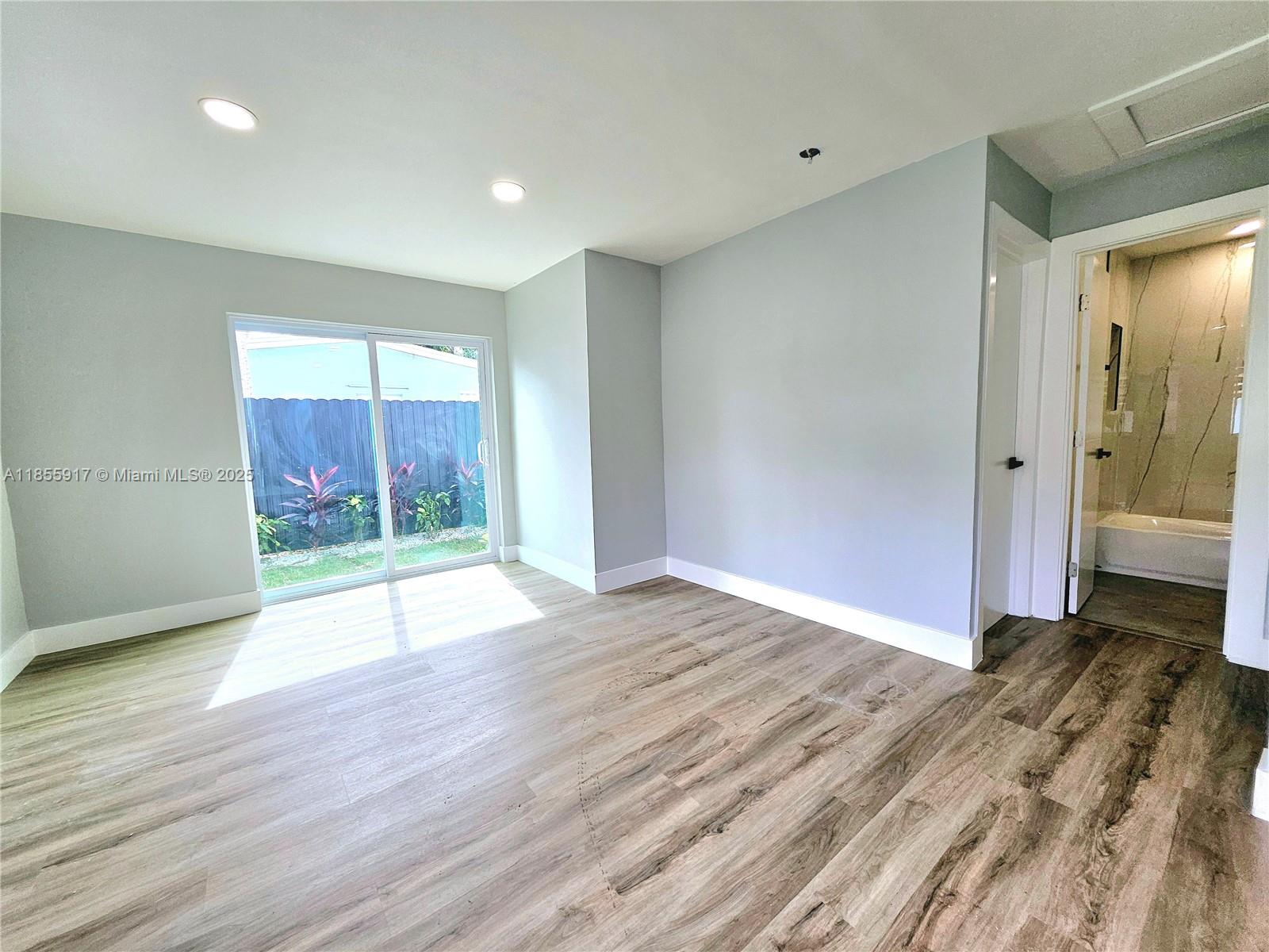 2865 Northeast 13th Avenue Pompano Beach, FL 33064 - Photo 3 of 19 a view of an empty room with wooden floor and a window
