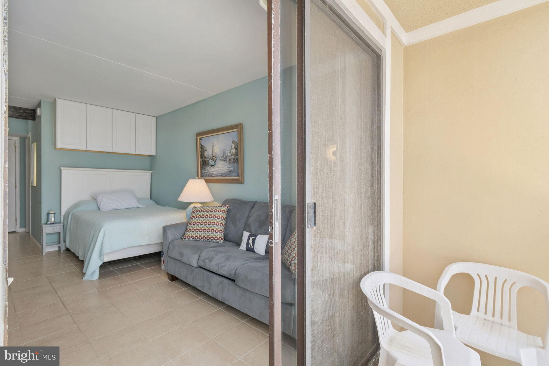 11 62nd Street, Unit 205 Ocean City, MD 21842 - Photo 10 of 18 a bedroom with a bed and chair