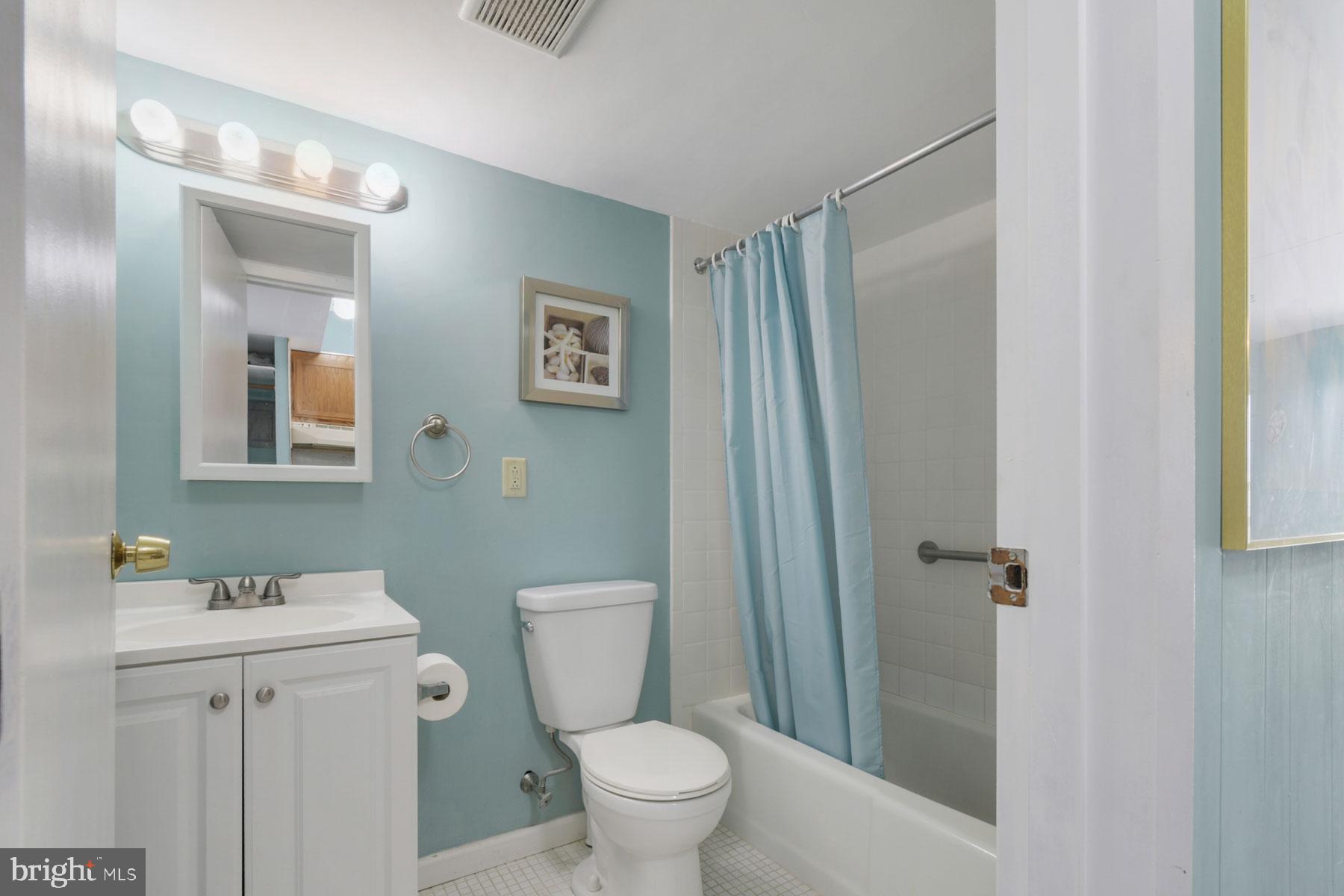 11 62nd Street, Unit 205 Ocean City, MD 21842 - Photo 13 of 18 a white toilet sitting next to a bathroom sink