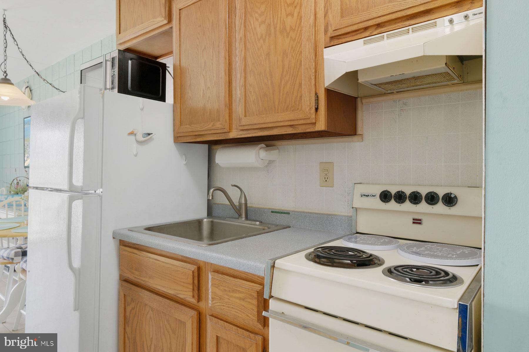11 62nd Street, Unit 205 Ocean City, MD 21842 - Photo 2 of 18 a kitchen with stainless steel appliances granite countertop a sink stove and refrigerator