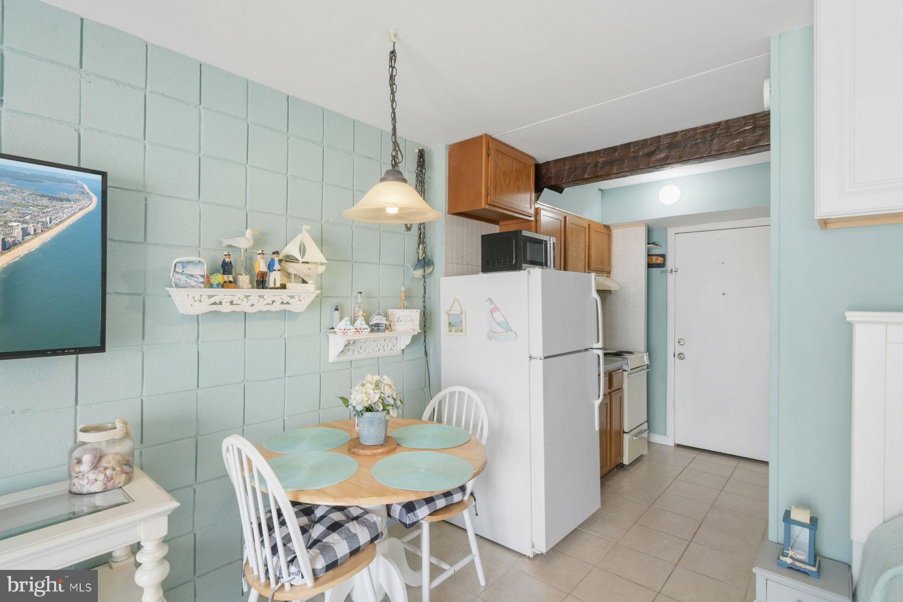 11 62nd Street, Unit 205 Ocean City, MD 21842 - Photo 5 of 18 a kitchen with a refrigerator a table and chairs in it