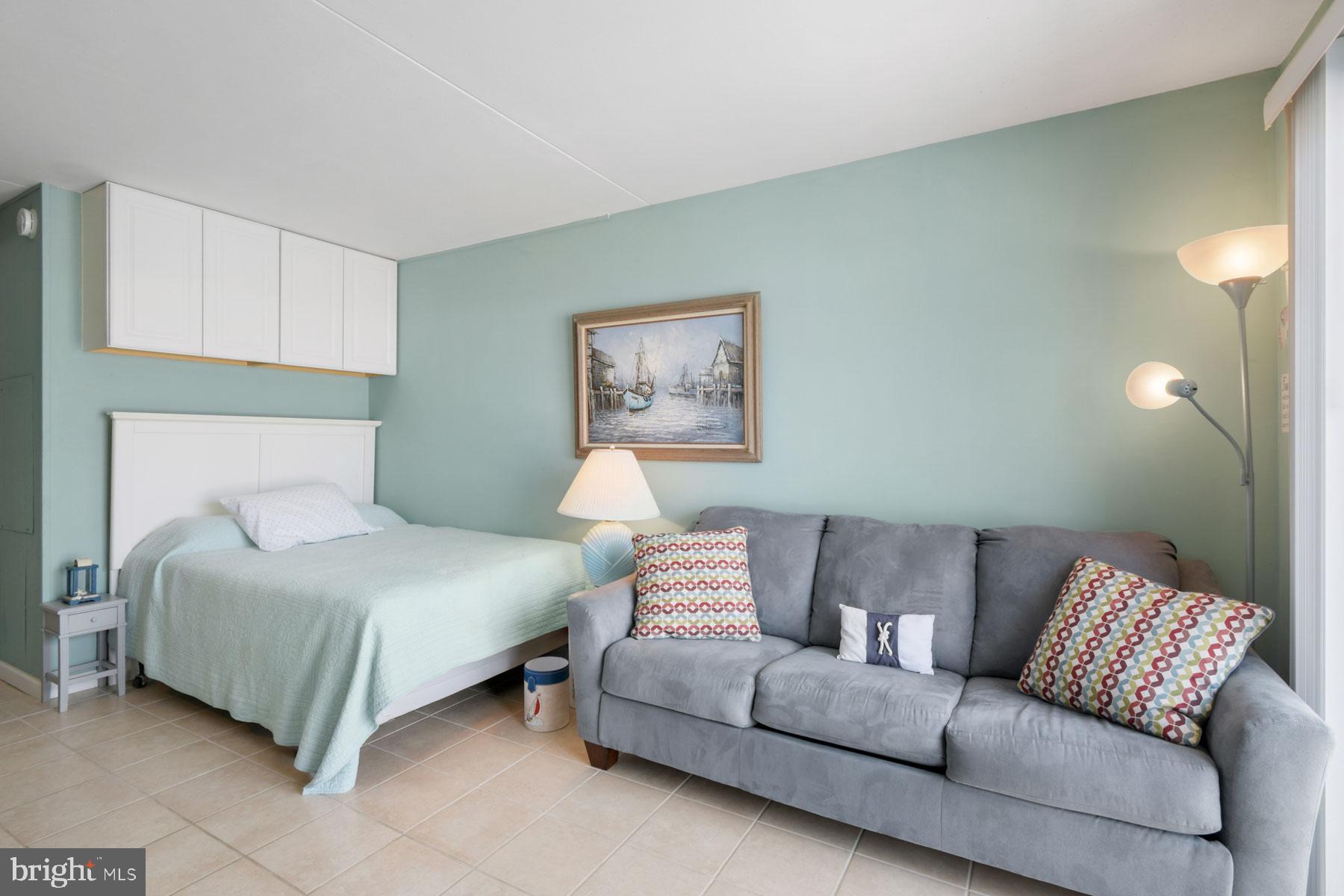 11 62nd Street, Unit 205 Ocean City, MD 21842 - Photo 8 of 18 a bedroom with a bed couch and window