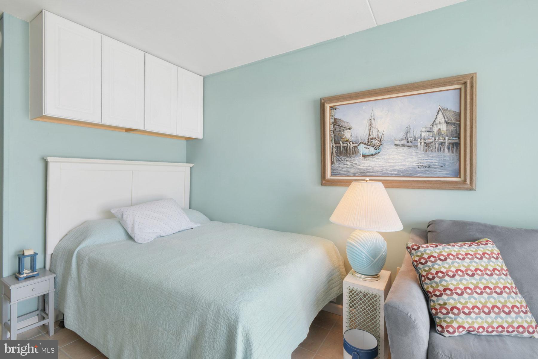 11 62nd Street, Unit 205 Ocean City, MD 21842 - Photo 9 of 18 a bedroom with a bed and a painting on the wall