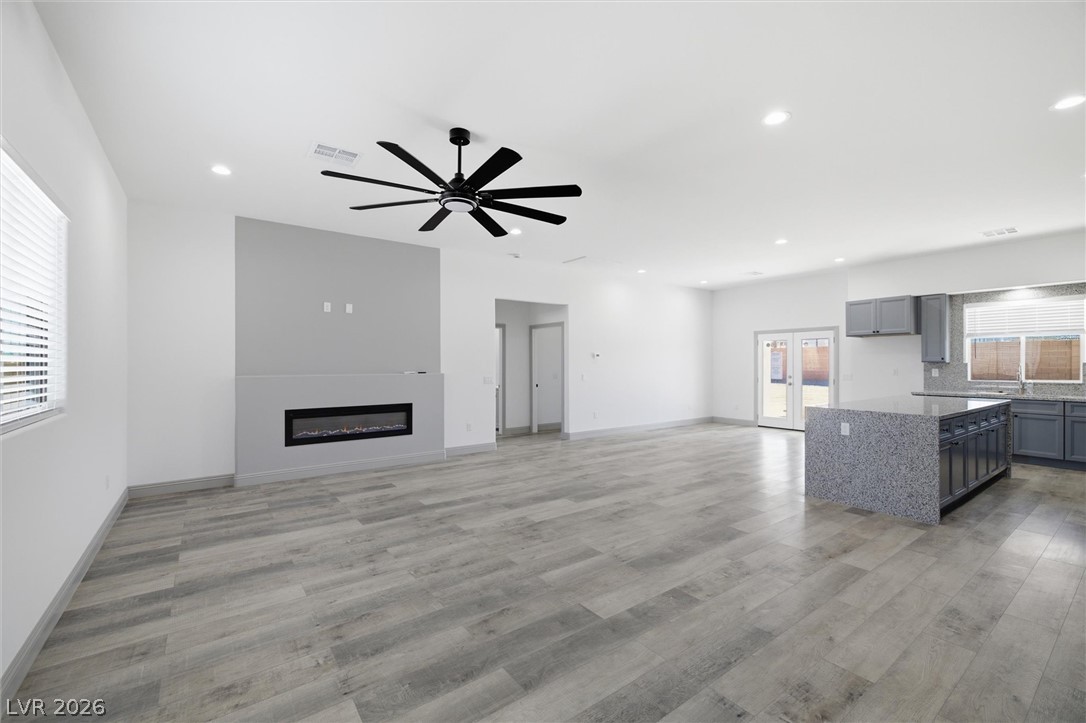 1061 Factory Road Pahrump, NV 89048 - Photo 4 of 41 An open-concept living area boasts a modern fireplace, stylish ceiling fan, and seamless kitchen island.