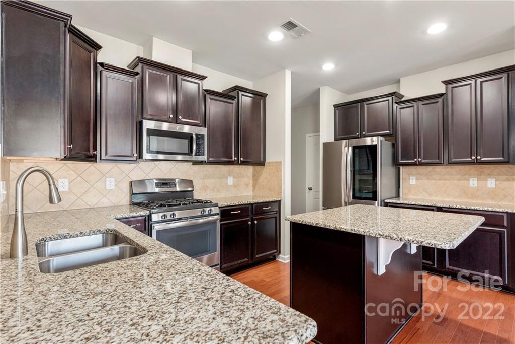 2831 Turquoise Circle Davidson, NC 28036 - Photo 11 of 44 a kitchen with stainless steel appliances granite countertop a refrigerator stove microwave and sink
