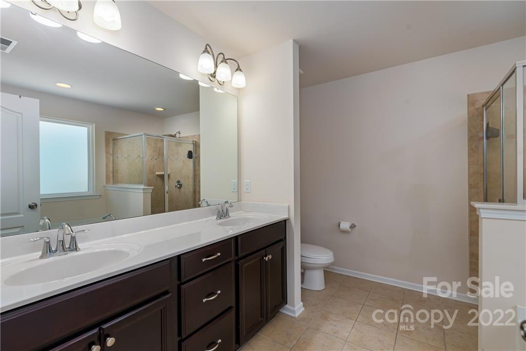 2831 Turquoise Circle Davidson, NC 28036 - Photo 24 of 44 a spacious bathroom with a granite countertop sink a toilet and a mirror