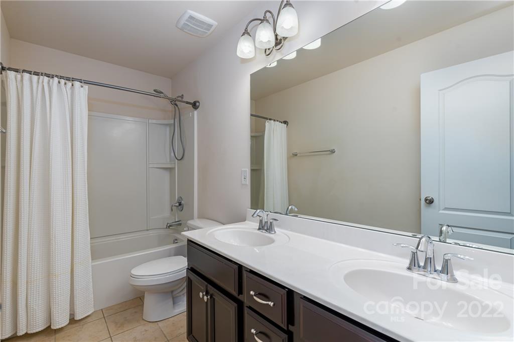 2831 Turquoise Circle Davidson, NC 28036 - Photo 33 of 44 a bathroom with a granite countertop sink a toilet a mirror and shower