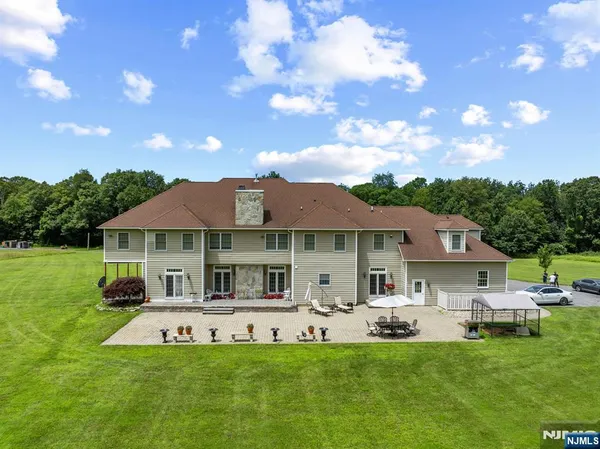 a front view of a house with a garden and swimming pool