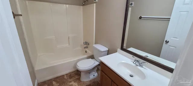 a white toilet sitting next to a bath tub