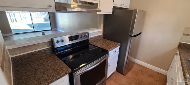 a stove top oven sitting inside of a kitchen