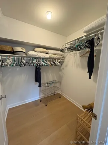 a view of walk in closet with clothes and shoes