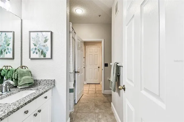 a bathroom with a granite countertop sink and a mirror