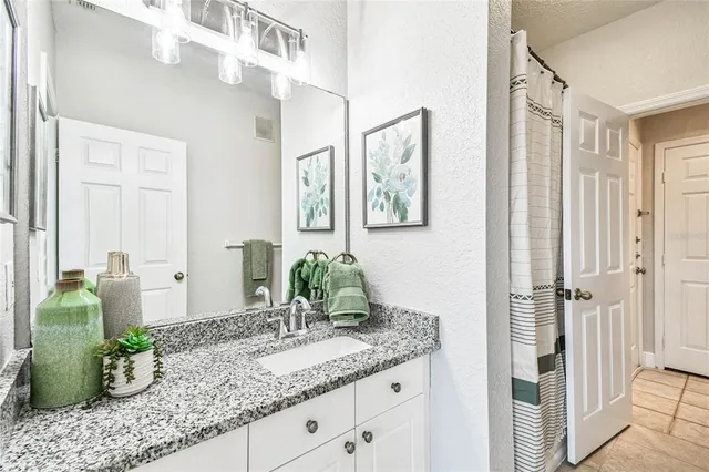 a bathroom with a granite countertop sink and a mirror