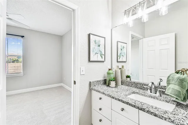 a bathroom with a granite countertop sink mirror and vanity