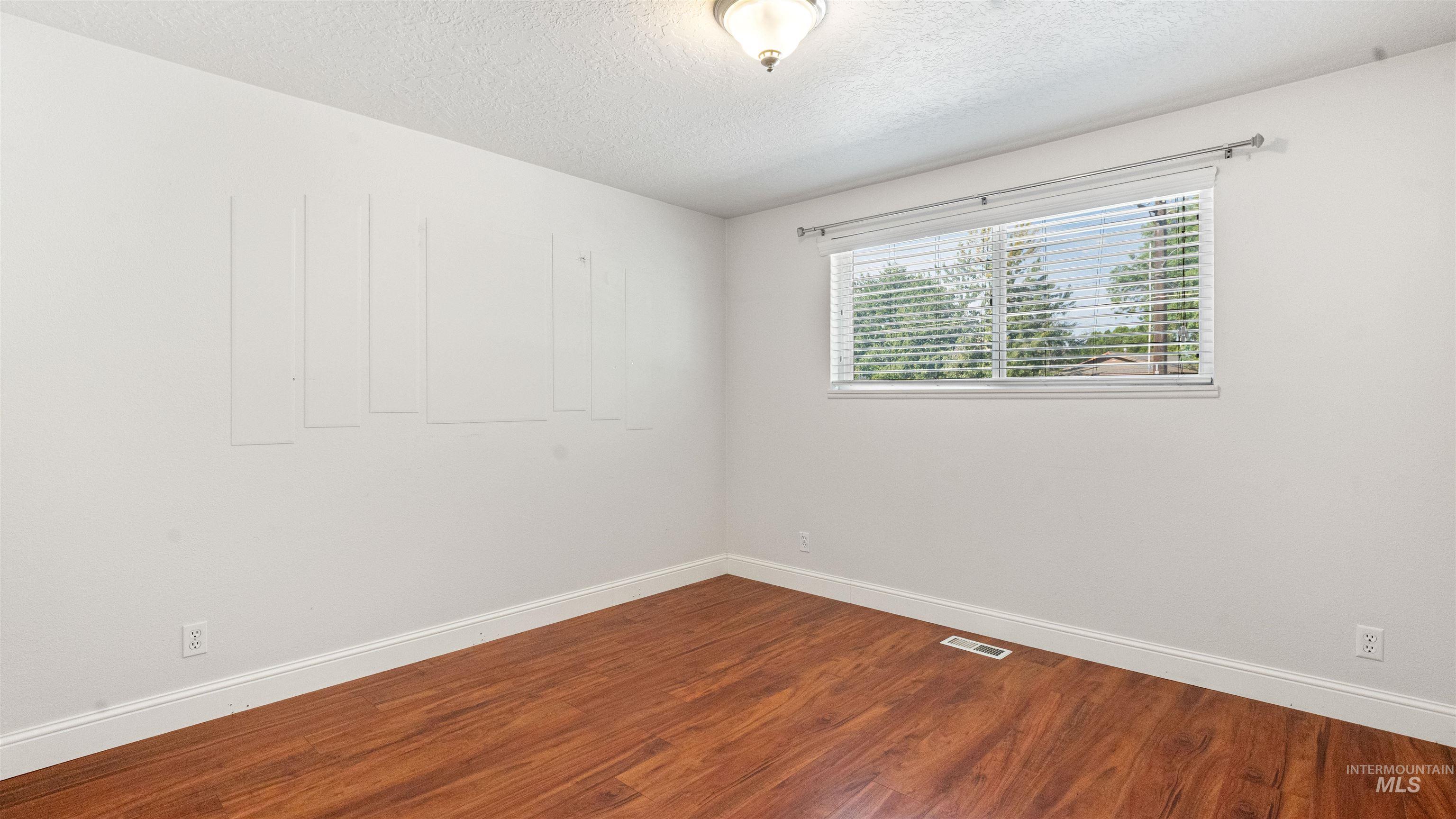 4054 North Maple Grove Road Boise, ID 83704 - Photo 27 of 34 Wood-finish flooring, white walls, and a bi-fold closet door