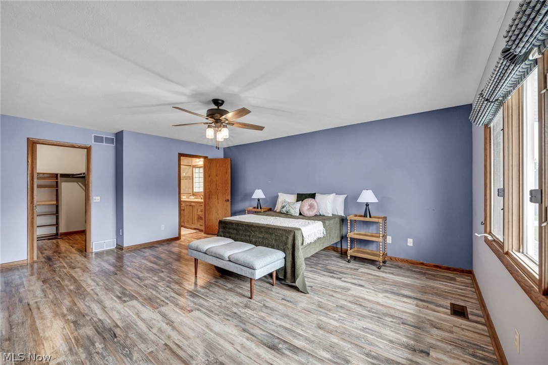 5162 Johnnycake Ridge Northeast Canton, OH 44705 - Photo 25 of 50 Bedroom with a spacious closet, light wood finished floors, ceiling fan, and ensuite bath