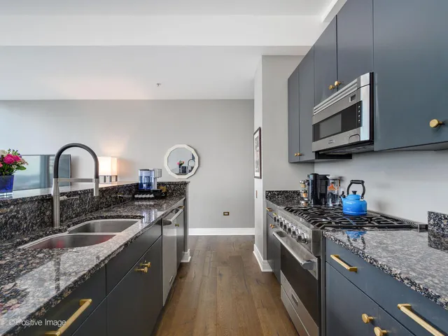 a kitchen with stainless steel appliances granite countertop a stove and a microwave