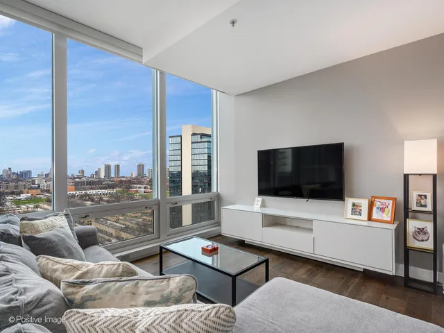 a living room with furniture kitchen view and a large window