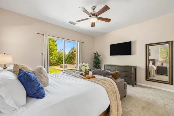 a bedroom with a bed a large window and a flat screen tv