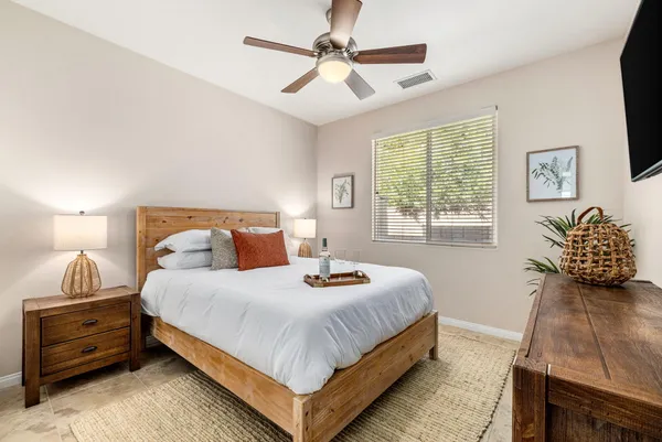 a bedroom with a bed and a flat tv screen on dresser