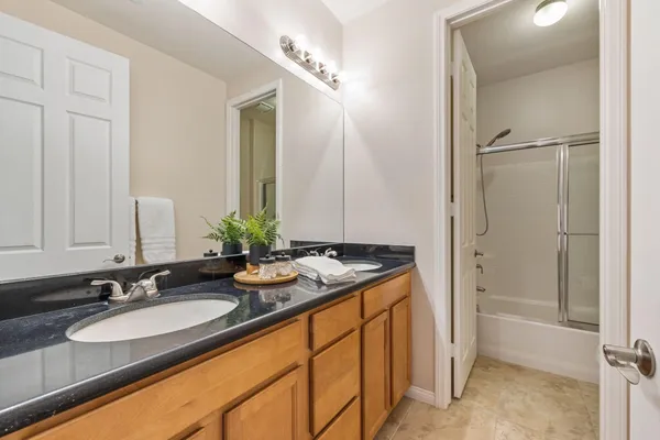 a bathroom with a granite countertop sink and a mirror