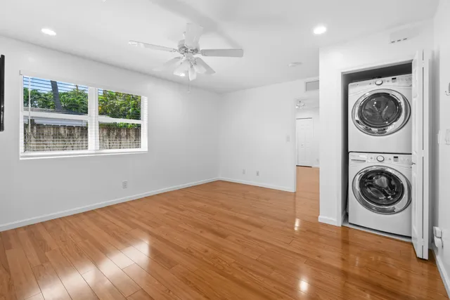 a view of a big room with wooden floor washing machine and dryer