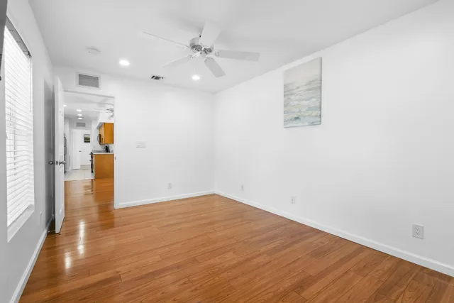 a view of empty room with wooden floor